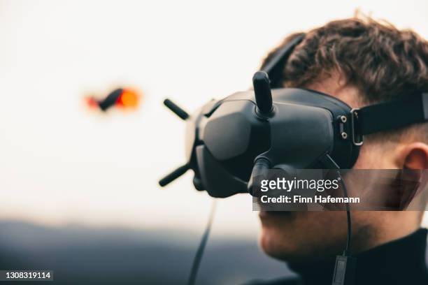 drone pilot flying fpv uav drone with fpv goggles - flying goggles imagens e fotografias de stock