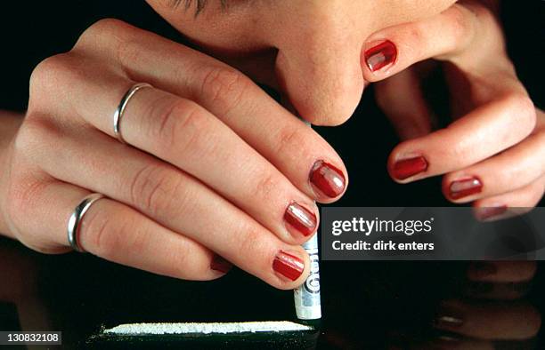 woman sniffs cocaine through banknote - customer needs stock pictures, royalty-free photos & images