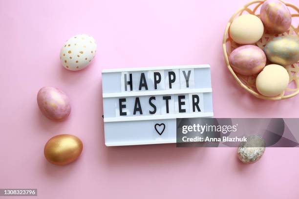 colorful easter eggs and dry flowers over pastel pink background. greeting card for holidays. lightbox with text happy easter. - citazione foto e immagini stock