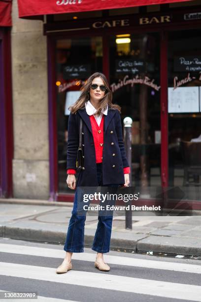 Therese Hellström wears Ray-Ban sunglasses, a white shirt with Peter Pan collar, a navy dark blue oversized military wool jacket with golden buttons,...