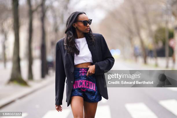 Emilie Joseph wears a black boyfriend blazer / oversized jacket from Zara Man, a white crew neck crop tee / t-shirt from HM, Muay Thai boxing /...