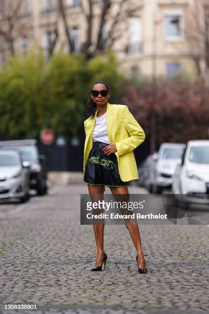 Emilie Joseph @in_fashionwetrust wears sunglasses, a white crew neck t-shirt from HM, a yellow oversized blazer jacket from Zara Man, sporty /...
