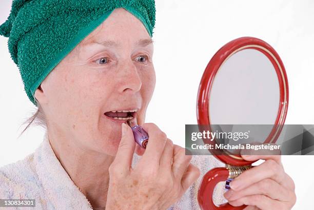 woman, older than 65 years, putting on makeup - 60 69 years imagens e fotografias de stock