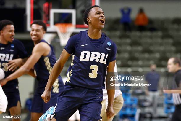 Max Abmas of the Oral Roberts Golden Eagles celebrates with teammates after defeating the Florida Gators in the second round game of the 2021 NCAA...