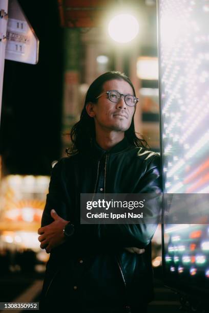 japanese man with long hair and eyeglasses at night in tokyo - asian man long hair stock pictures, royalty-free photos & images