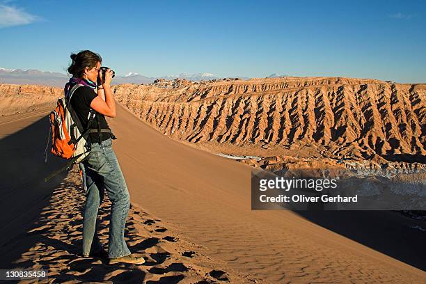 woman with a camera on a sand dune in the moon valley (valle de la luna), atacama desert, northern chile, south america - norte imagens e fotografias de stock