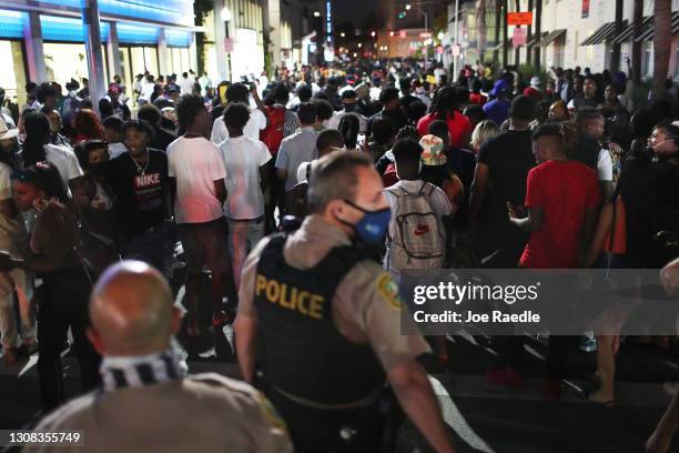 People leave the area as an 8pm curfew goes into effect on March 21, 2021 in Miami Beach, Florida. College students have arrived in the South Florida...