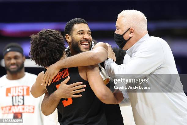 Maurice Calloo and Ethan Thompson of the Oregon State Beavers celebrate their 80-70 win with their head coach Wayne Tinkle over the Oklahoma State...