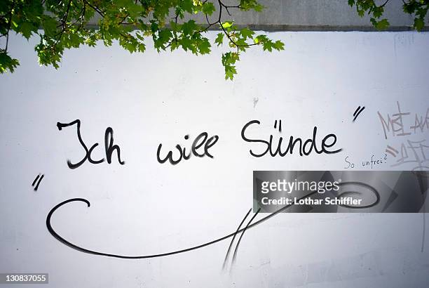 ich will suende (i want sin), graffiti on a white wall - catchwords stockfoto's en -beelden