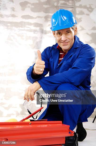 workman wearing a hard hat, kneeling in front of a toolbox - tradesman toolkit stock pictures, royalty-free photos & images
