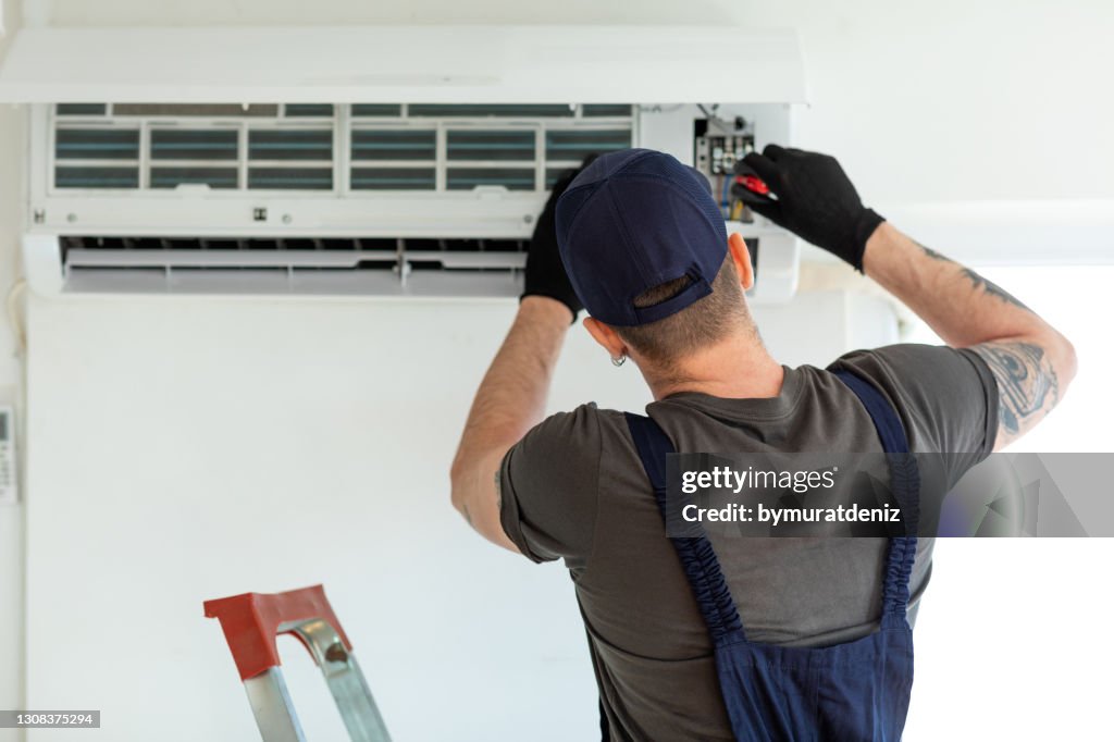Technicien réparant le climatiseur