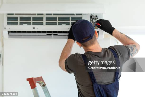 technician repairing air conditioner - repairing stock pictures, royalty-free photos & images