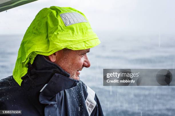 happy skipper on sailboat in heavy rain - sailing storm stock pictures, royalty-free photos & images