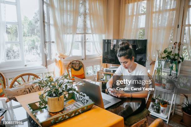 hispanic college student doing some home works from home with laptop - cute college girl stockfoto's en -beelden