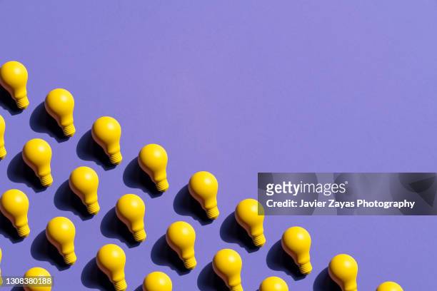 some yellow incandescent light bulbs on purple background - ideas stock pictures, royalty-free photos & images