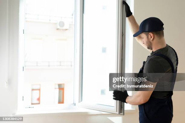 homme à tout faire fixant la fenêtre - window photos et images de collection