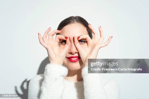 woman making artificial eyeglasses with hands - hand glasses stockfoto's en -beelden