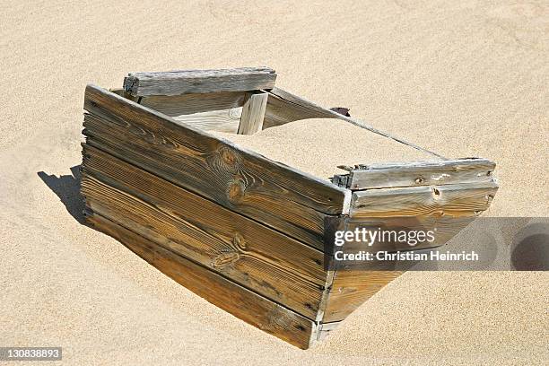in sand sunken wooden box in the former diamondtown (ghosttown) kolmanskop in the namib desert, luederitz, namibia, africa - kolmanskop namibia stock pictures, royalty-free photos & images