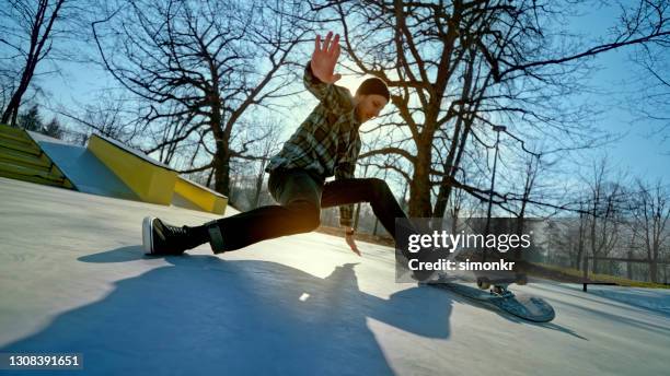 junger mann stürzt von skateboard in skateboard-park - skateboard fall stock-fotos und bilder