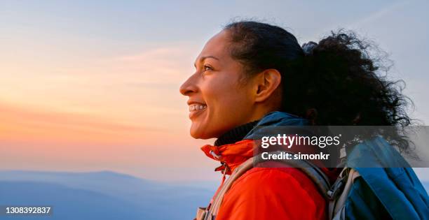 reife frau, die die sicht betrachtet, während sie gegen den himmel steht - landschaft rot stock-fotos und bilder