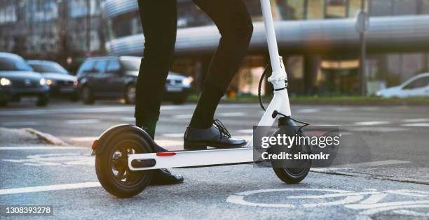 businesswoman riding electric push scooter - electric push scooter stock pictures, royalty-free photos & images