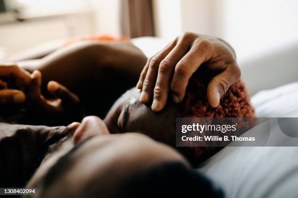 two men embracing while laying in bed together - pareja abrazados cama fotografías e imágenes de stock