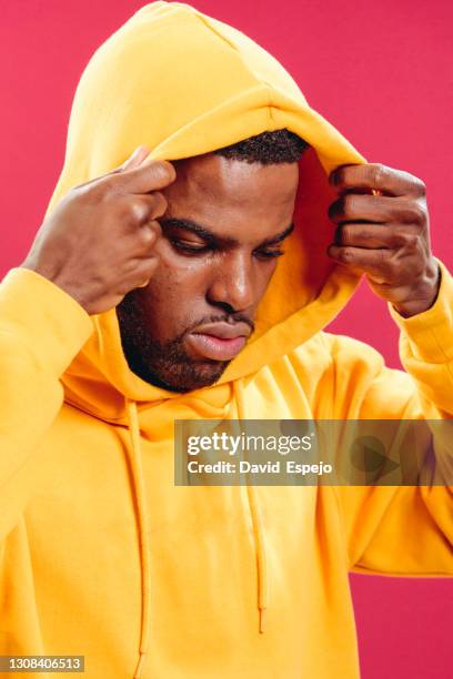 black man in yellow hoodie - hood clothing stock pictures, royalty-free photos & images