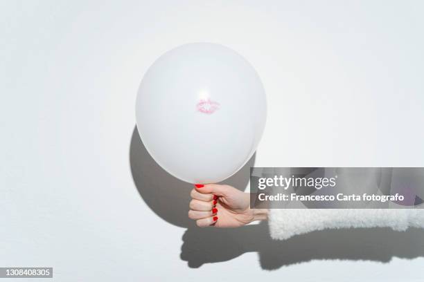 woman holding balloon against white background - red lipstick kiss stock pictures, royalty-free photos & images