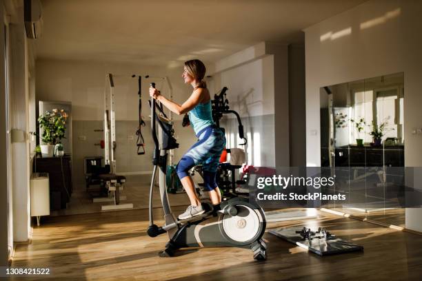 happy athletic woman cycling on exercise bike - equipamento de treino imagens e fotografias de stock