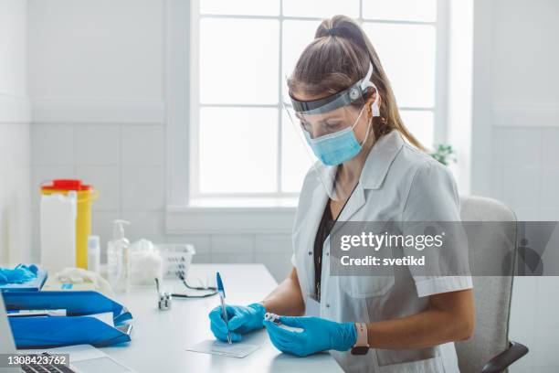 enfermera preparando vacuna - inmunologia fotografías e imágenes de stock