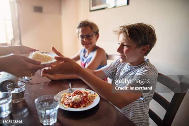 ragazzini che si godono il pranzo degli spaghetti - lunch cheese foto e immagini stock