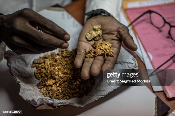 Diamond and gold dealer inspects nuggets of gold in his shop on March 15, 2021 in the capital Bangui, Central African Republic. The United Nations...