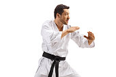 Man in kimono with black belt practicing karate