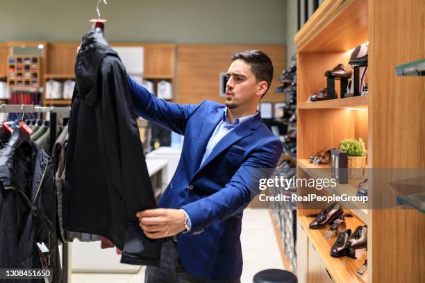 el hombre compra ropa tienda de moda ropa masculina traje esmoquin, concepto de ropa a medida. - abrigo blanco artículo de moda fotografías e imágenes de stock