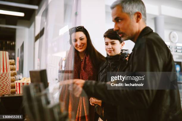 familia comprando boletos mientras la pandemia se relaja - ticket counter fotografías e imágenes de stock