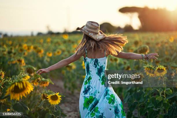 teenage girl enjoying sunflowers in tuscany - girl gold dress stock pictures, royalty-free photos & images