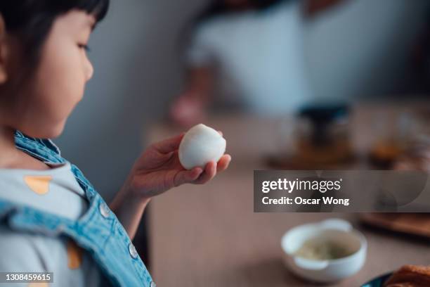 girl eating boiled eggs at home - gekochtes ei stock-fotos und bilder