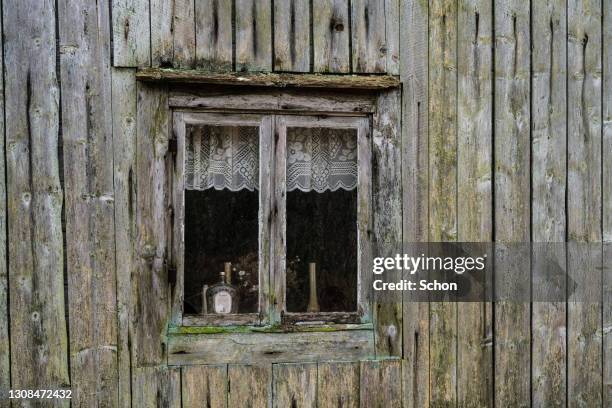 a window on an old abandoned cottage - wooden hut stock pictures, royalty-free photos & images