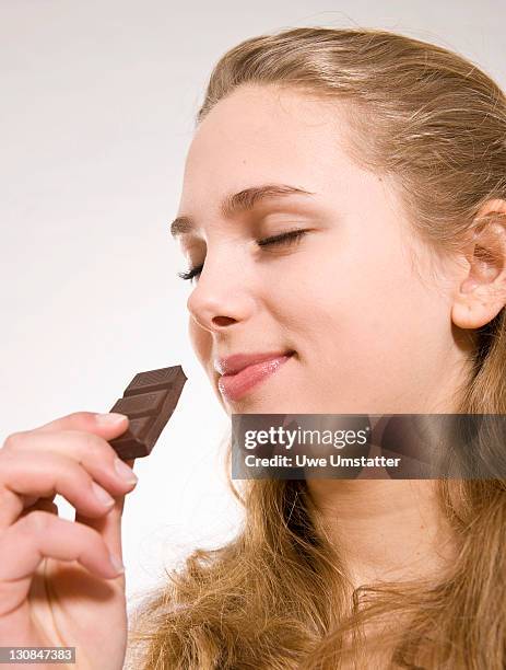 teenage girl enjoying a piece of chocolate - close up of chocolates for sale stock pictures, royalty-free photos & images