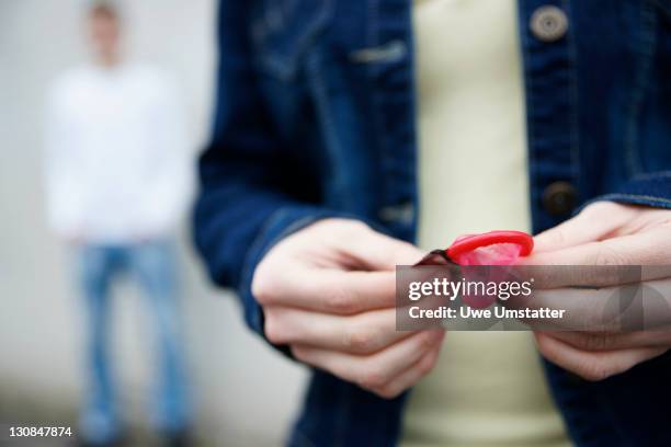 adolescent holding a condom - condoms stock pictures, royalty-free photos & images