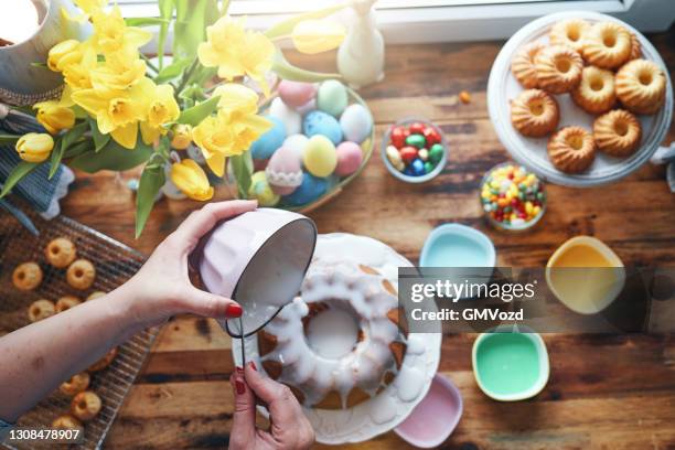 het voorbereiden van kleine cakes van de bunt van pasen met glazuur - paastaart stockfoto's en -beelden