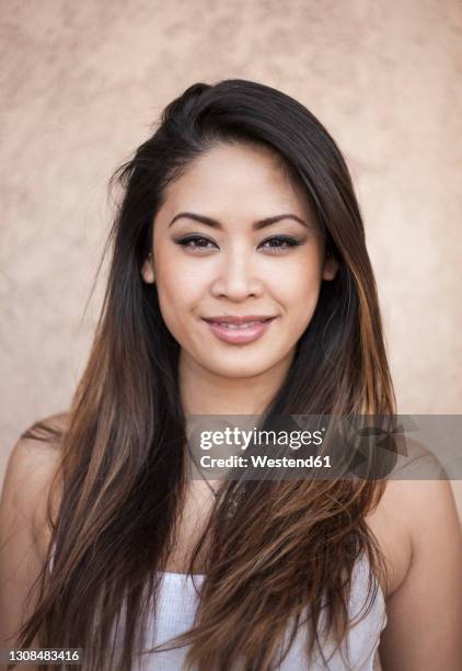 smiling beautiful young woman against wall - balayage foto e immagini stock