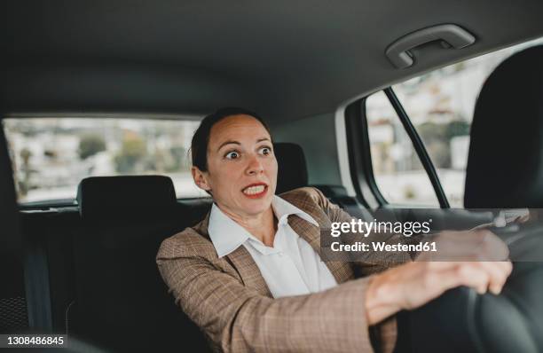 scared businesswoman in back seat of car - horrible car accidents foto e immagini stock