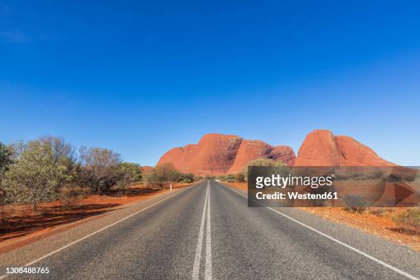 australia, northern territory, kata tjuta road through central australian desert - northern territory australia stock pictures, royalty-free photos & images