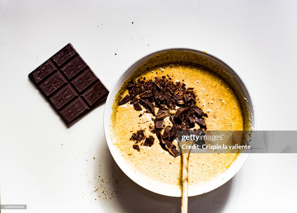 Chocolate tart dough and dark chocolate bar on white background