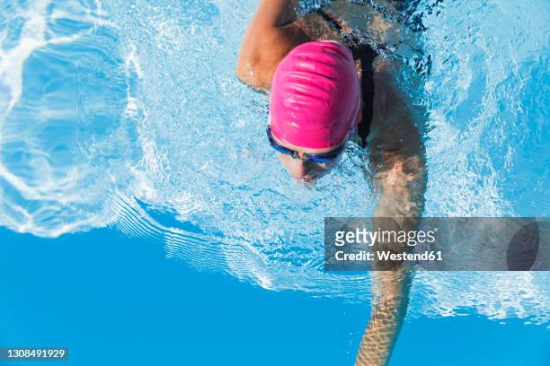 woman swimming in clear blue swimming pool - blue magenta stock pictures, royalty-free photos & images