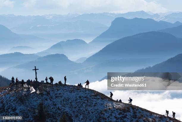 border region austria germany, heuberg, silhouettes of backpackers hiking to mountain peak - chiemgau photos et images de collection