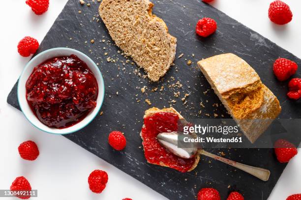 slices of bread, fresh raspberries and bowl of raspberry jam - raspberry jam stock pictures, royalty-free photos & images