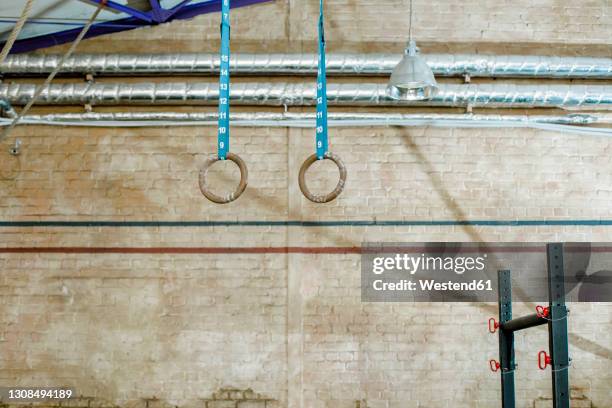 gymnastic rings hanging against wall at health club - gymnastic rings equipment bildbanksfoton och bilder