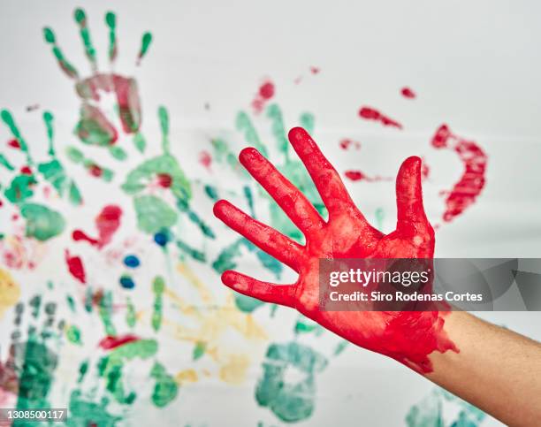 hand painted red on colorful hand prints - handabdruck stock-fotos und bilder